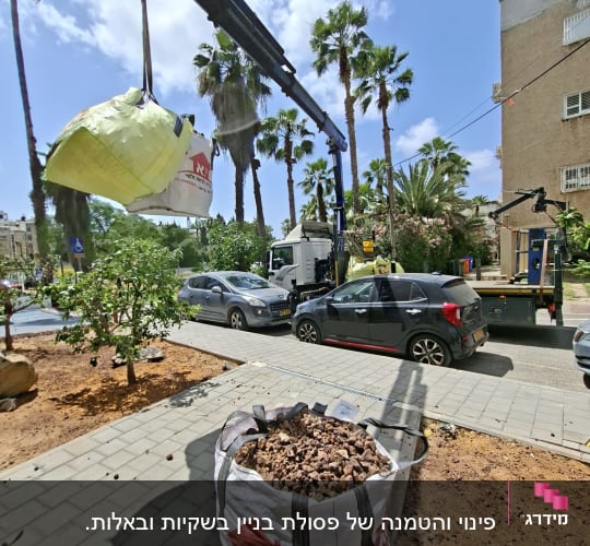 מנוף מרים שק כבד ברחוב עם עצים ומכוניות